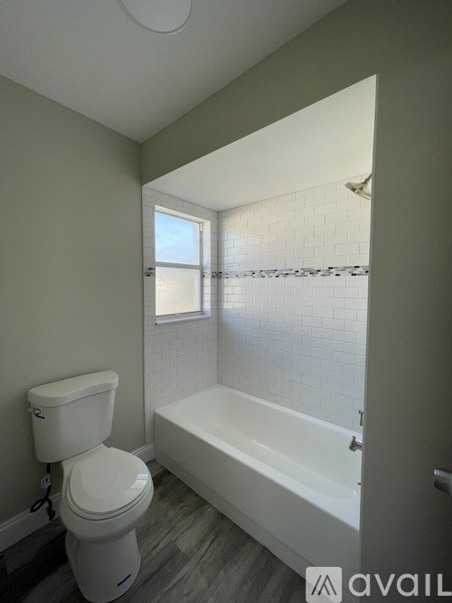 A white toilet is next to a bathtub in a bathroom.