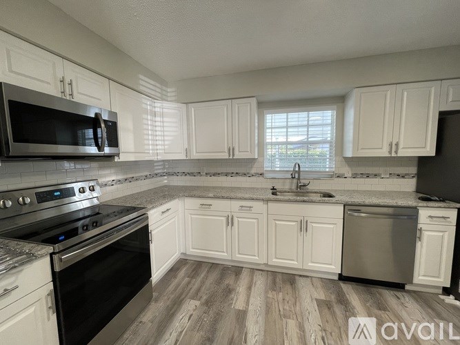 A kitchen with white cabinets and a black oven.