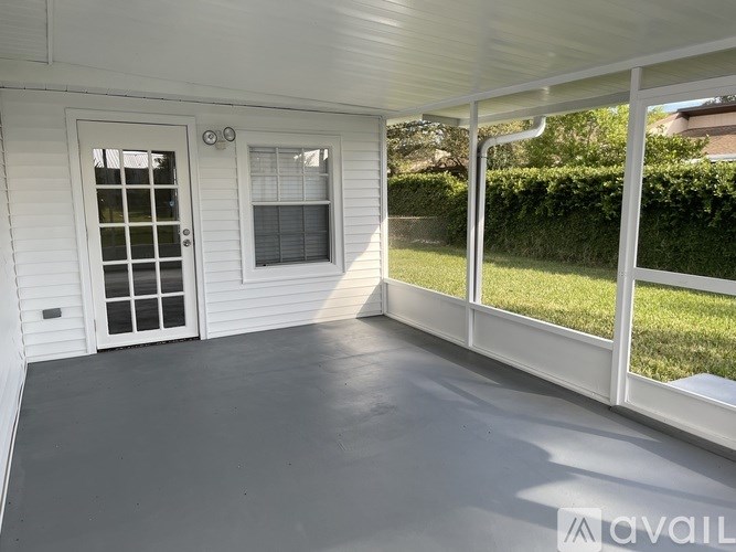 A white house with a patio and a door.