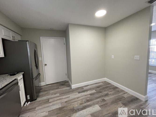 A kitchen with a black fridge and a white door.