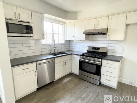 A kitchen with white cabinets and stainless steel appliances.