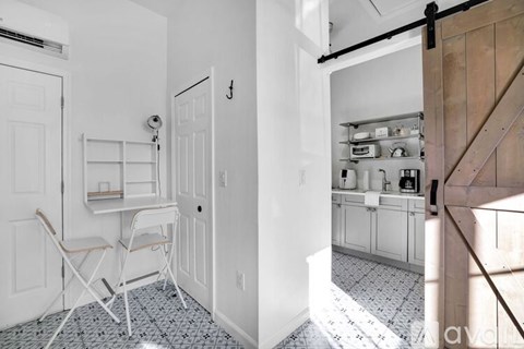 A kitchen with a white table and chairs.