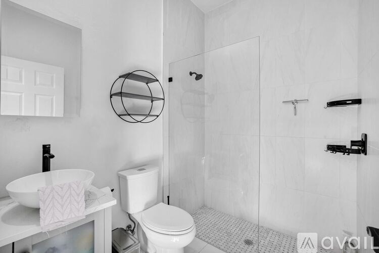 A white bathroom with a toilet, sink, and shower.
