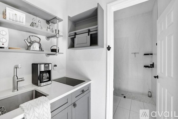 A kitchen with a sink, microwave, and a toaster on the counter.