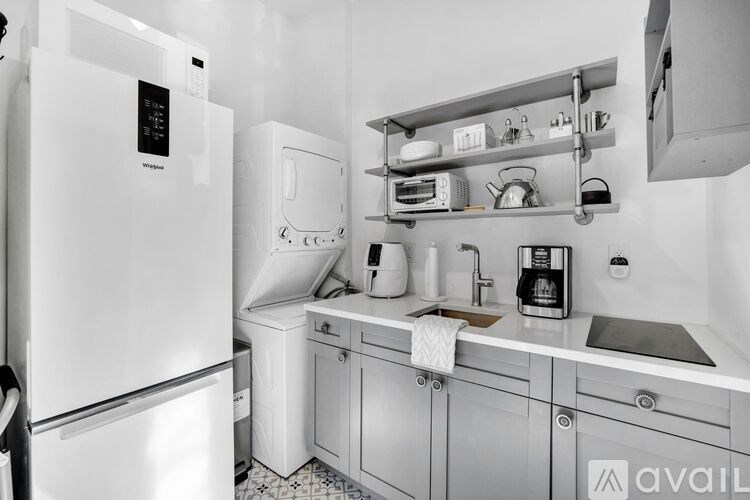 A kitchen with white appliances and white cabinets.