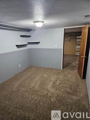 A room with a carpeted floor and a doorway leading to another room.