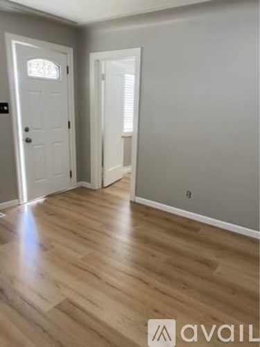A room with a wooden floor and two white doors.