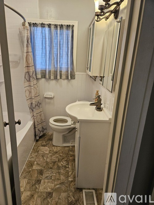A bathroom with a toilet, sink, and shower.