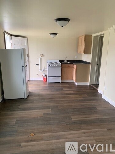 A kitchen with a refrigerator, oven, and cabinets.