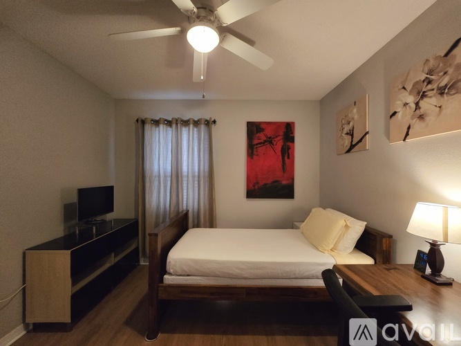 A bedroom with a bed, desk, and chair.