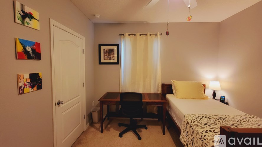 A bedroom with a bed, desk, and chair.