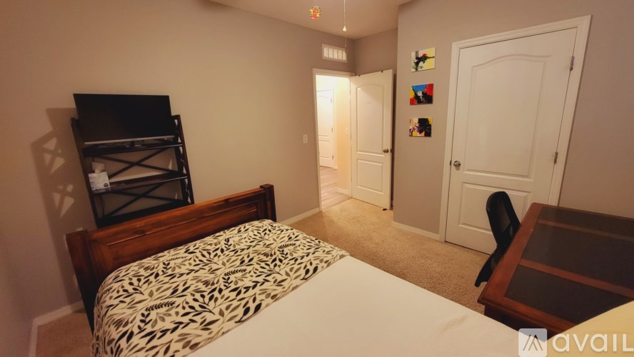 A bedroom with a bed, a chair, and a TV.