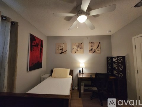 A bedroom with a bed, a chair, and a TV.