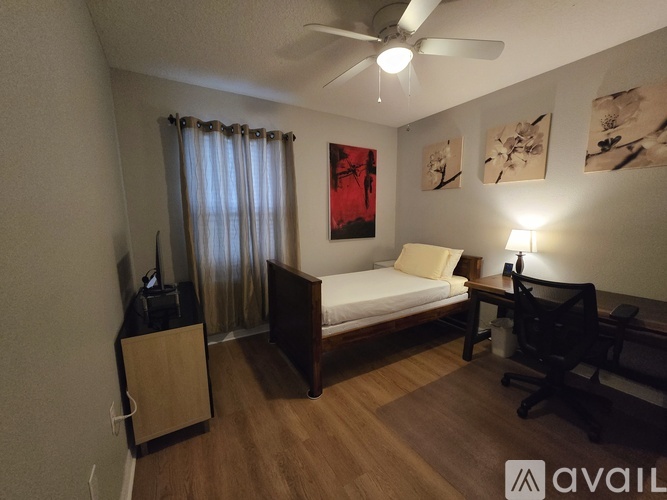 A bedroom with a bed, nightstand, and a ceiling fan.