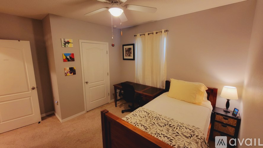 A bedroom with a bed, nightstand, and a ceiling fan.