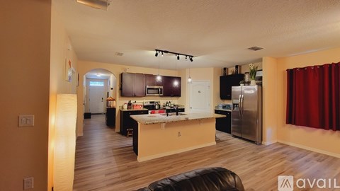 A kitchen with a refrigerator, microwave, and oven is available for rent.
