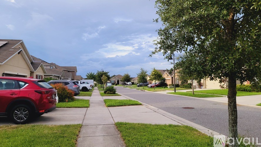 A red car is parked on the side of a street.