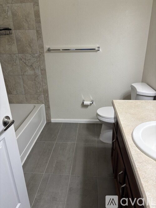 A bathroom with a toilet, sink, and tiled floor.