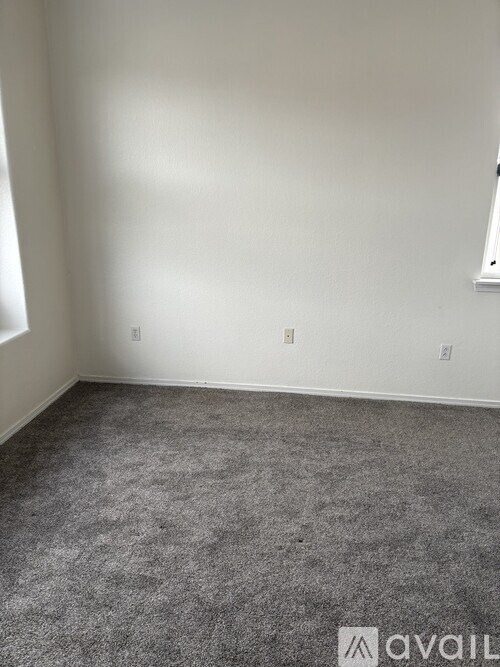 A room with grey carpet and white walls.