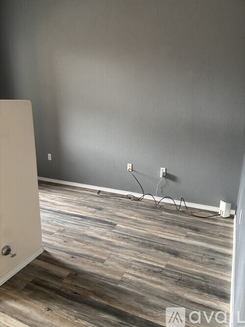 A room with a wooden floor and a white door.