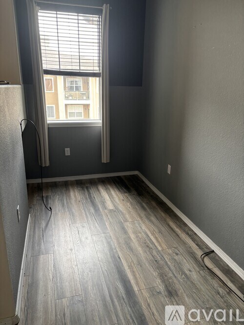 A room with a window and wooden flooring.