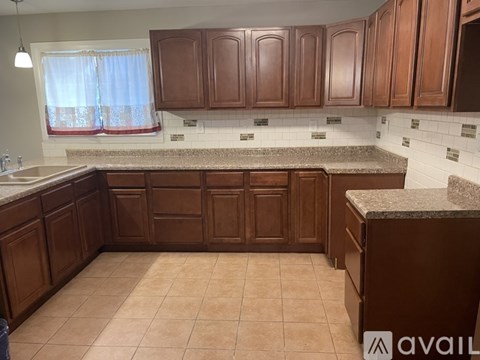 A kitchen with brown cabinets and a granite countertop.