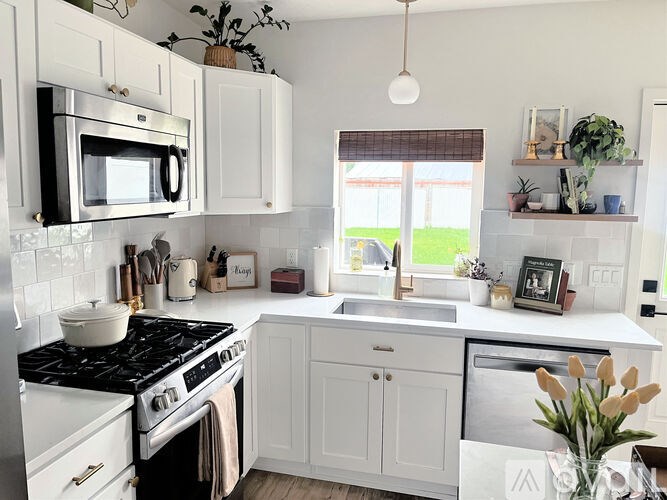A kitchen with white cabinets and a black stove top.