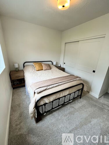 A bedroom with a bed, nightstand, and lamp.