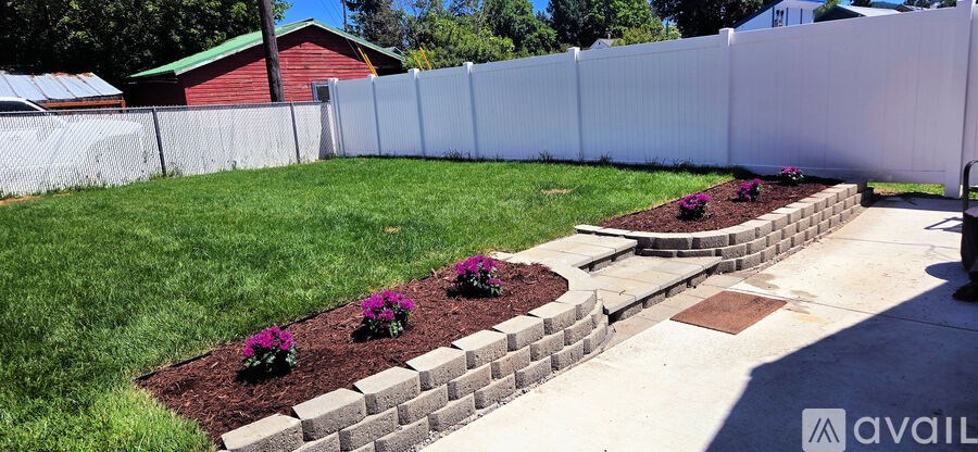 A white fence with a brick planter box in the middle.