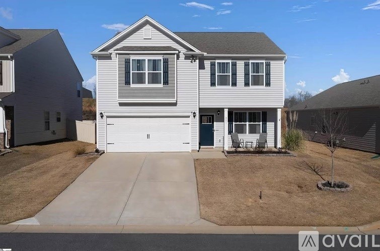 A house with a grey roof and white garage door is for sale.