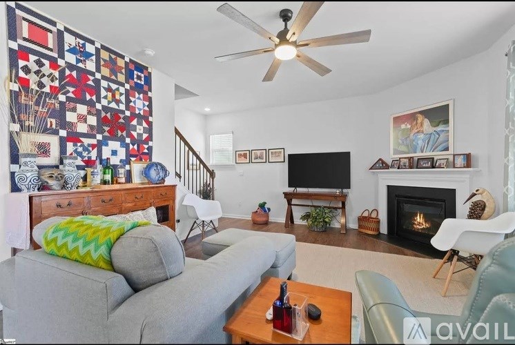 A living room with a grey couch, a coffee table, a fireplace, and a TV.