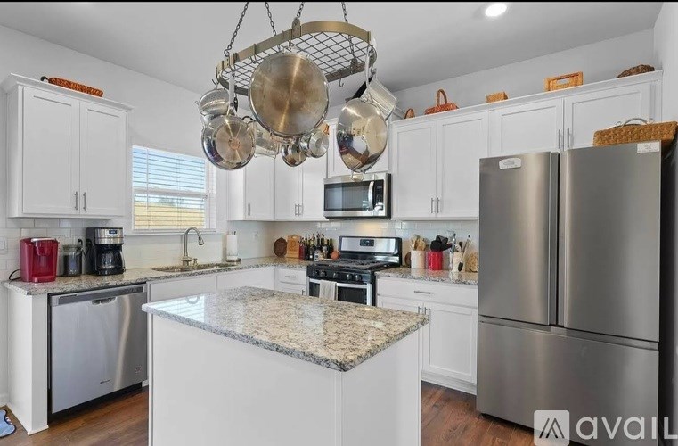 A kitchen with a granite countertop and stainless steel appliances.