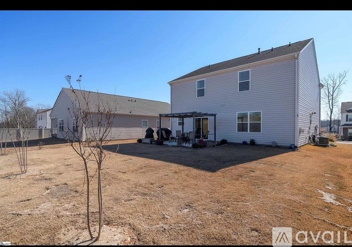 A house with a yard and a tree in front of it.