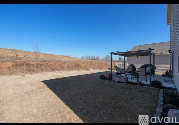 A backyard with a patio and a house.