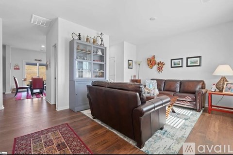 A living room with brown leather couches and a rug.