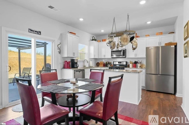 A kitchen with a table and chairs in front of it.