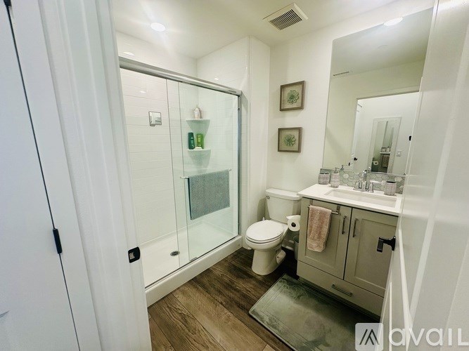 A bathroom with a toilet, sink, and shower.