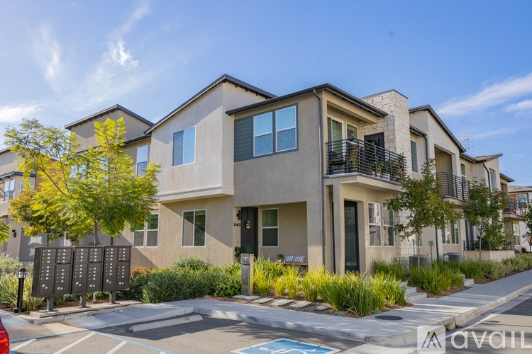 A modern two-story house with a balcony on the second floor.