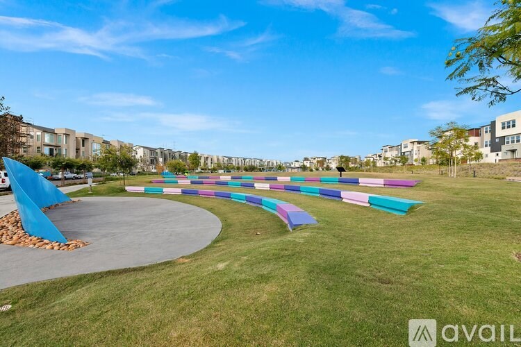 A park with a pathway and colorful benches.