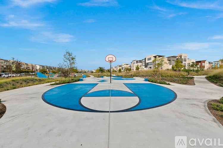 A basketball court with a blue and white surface and a sign with a basketball hoop on it.