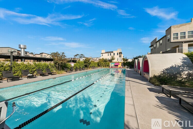 A long outdoor swimming pool with lane markers and sun loungers.