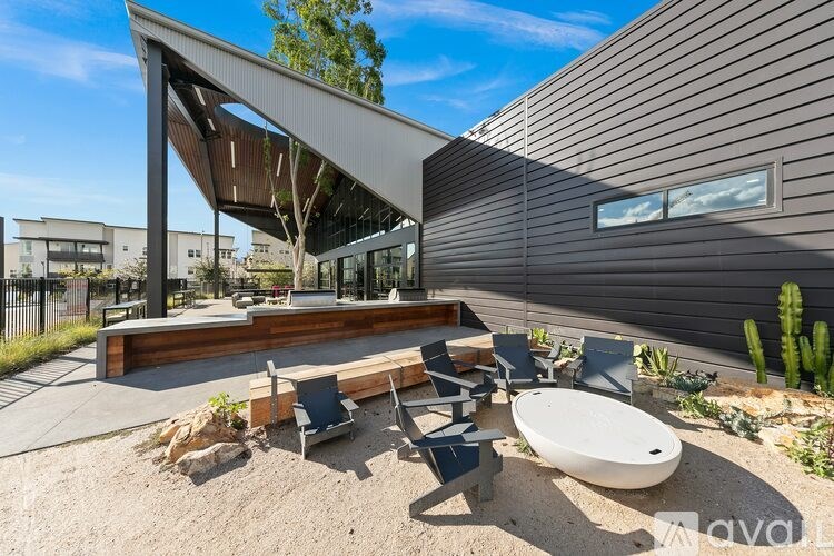 A modern outdoor seating area with a white table and chairs.