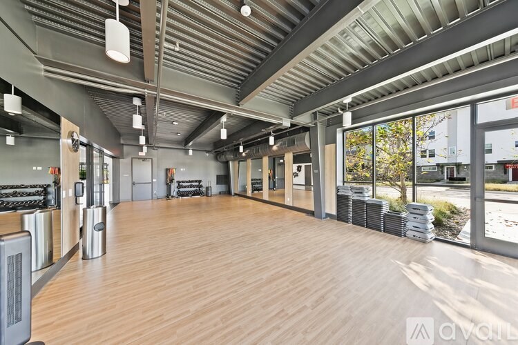 A spacious room with wooden floors and a ceiling with metal beams.