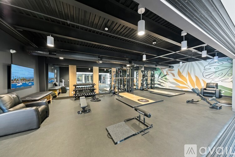 A spacious gym with a variety of equipment including a treadmill, weights, and a bench press.