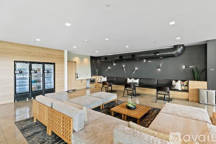A modern living room with a black couch and a wooden coffee table.