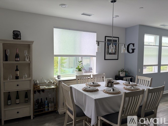 A dining room with a white table set for six.