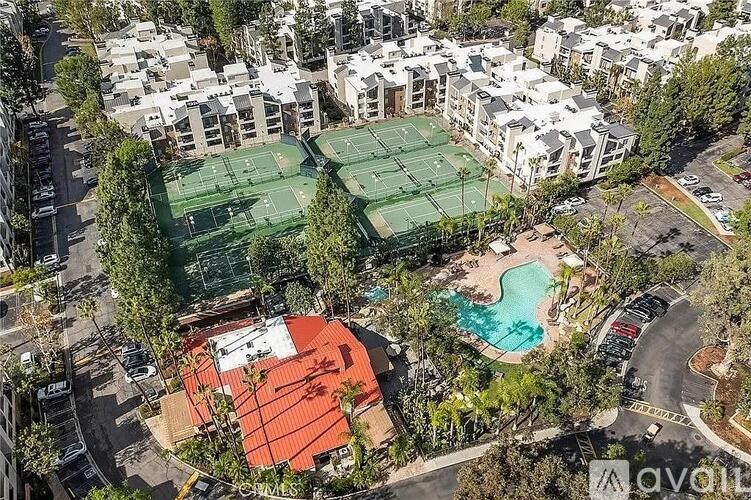 An aerial view of a tennis court surrounded by buildings.