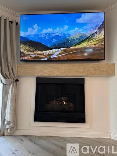 A modern living room with a flat screen TV mounted above a fireplace.