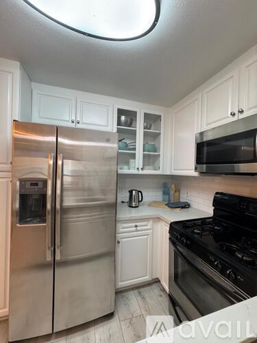 A kitchen with a stainless steel refrigerator and black stove.