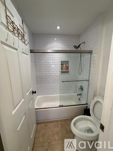 A bathroom with a toilet, tub, and shower.